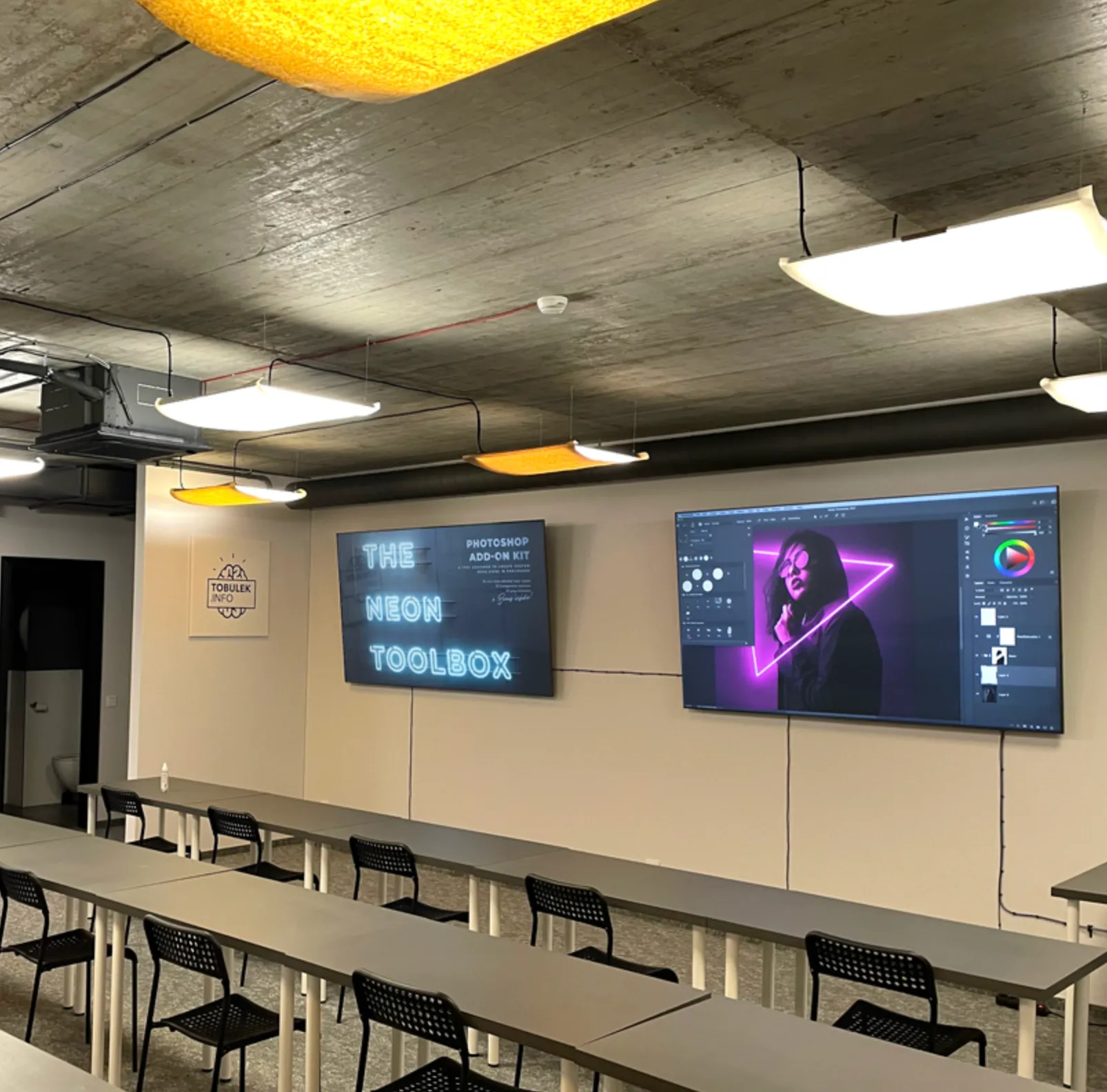 Tobulėk.INFO grafinio dizaino mokymo klasė su interaktyviais Photoshop ekranais ir studentų darbo vietomis